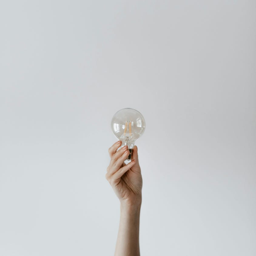 Anonymous female showing light bulb